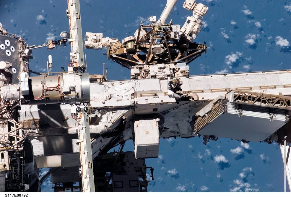 exterior view of portion of ISS, with blue-hued Earth in background
