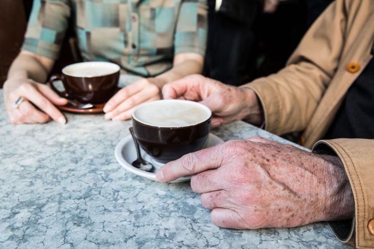 Two people holding coffee. 